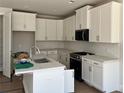 Well-lit kitchen features white cabinets, stainless steel appliances, and a stylish backsplash at 1063 Crest Mill Dr, Marietta, GA 30008