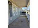 The front porch of a single-story home has a white railing and traditional light fixture at 325 Villa Rosa Way, Temple, GA 30179