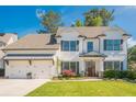 Inviting two-story home with a three-car garage, manicured lawn, and charming front garden at 513 Beecham Dr, Smyrna, GA 30082