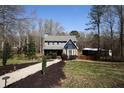 View of home showing a large lawn, mature trees, and additional outdoor storage at 92 Indian Lake Ct, Hiram, GA 30141