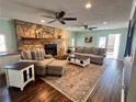 Cozy living room featuring a stone fireplace, hardwood floors, and ample seating with neutral decor at 92 Indian Lake Ct, Hiram, GA 30141