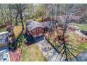 An aerial view of a wood-sided home surrounded by mature trees and a well-manicured lawn at 2685 Whippoorwill Cir, Duluth, GA 30097