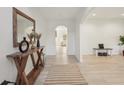 Inviting foyer featuring light wood floors, stylish console table, and an arched doorway at 1811 Penny Nw Ln, Lawrenceville, GA 30043