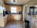 Functional kitchen features tile flooring, wood cabinets, and bright natural light at 3511 Flint Ave, Ellenwood, GA 30294