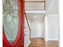 Beautiful foyer featuring hardwood floors, a staircase, and a red front door with glass detailing at 385 Sweet Ivy Ln, Lawrenceville, GA 30043