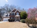 Charming two-story brick home with manicured landscaping, a two-car garage, and a welcoming front entrance at 100 Cross Creek Dr, Lilburn, GA 30047