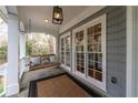 Inviting front porch with a swing, stylish lighting, and views of the surrounding trees at 3776 Powers Ferry Nw Rd, Atlanta, GA 30342