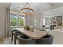 Bright dining area with a large window, modern chandelier, and seamless transition to the living room at 420 Hatcher Ct, Hampton, GA 30228