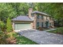 Brick home with attached garage and a long driveway, surrounded by mature trees, offering privacy at 2982 Huntshire Pl, Atlanta, GA 30340
