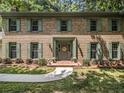 Attractive brick home featuring green shutters, a welcoming front door, and well-maintained landscaping at 2982 Huntshire Pl, Atlanta, GA 30340