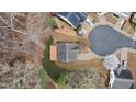Bird's-eye view of a home with a lush backyard, deck, mature trees, and a circular driveway at 4019 Somersal Ct, Cumming, GA 30040