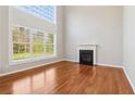 Bright living room featuring a fireplace, hardwood floors, and large, light-filled windows at 4677 Creekside Cv, Atlanta, GA 30349