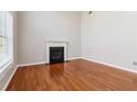 Spacious living room with hardwood floors, a fireplace, and large windows providing natural light at 4677 Creekside Cv, Atlanta, GA 30349