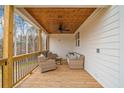 Inviting back deck featuring wood ceiling, comfortable seating, and privacy at 776 Geneva Rd, Canton, GA 30114