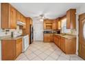 Well-lit kitchen with wood cabinets, granite countertops, stainless steel refrigerator, and tile floors at 1532 Wethersfield Rd, Snellville, GA 30078