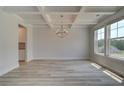 Open living area with coffered ceilings, large windows, and plank flooring at 141 Compass Rd, Hampton, GA 30228