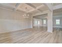 Elegant dining room showcasing a decorative chandelier, wainscoting, and light wood floors at 145 Compass Rd, Hampton, GA 30228