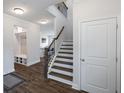 Inviting entryway featuring hardwood floors, staircase, built-in shelving and a convenient coat rack at 319 Hayden Cir, Woodstock, GA 30189