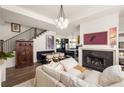 Open concept living room with modern fireplace, hardwood floors, and staircase to the upper level at 11572 Serenbe Ln, Chattahoochee Hills, GA 30268