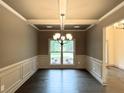 Elegant dining room featuring wainscoting, a decorative chandelier, and a large window at 121 Honey Creek Rd, Conyers, GA 30094