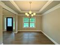 Elegant dining room featuring wood floors, crown molding, and a stylish chandelier at 123 Honey Creek Rd, Conyers, GA 30094