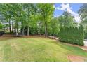 Spacious backyard featuring a trampoline and mature trees creating a private oasis at 3070 Corsair Curv, Cumming, GA 30040