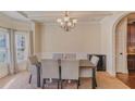 Formal dining room with wainscoting, chandelier, seating for six, and hardwood flooring at 7347 Moss Stone Dr, Conyers, GA 30094