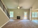 Spacious living room featuring a fireplace, staircase, and access to the outdoors at 125 Honey Creek Rd, Conyers, GA 30094