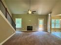 Spacious living room featuring a fireplace, large windows, and a ceiling fan, providing ample natural light at 125 Honey Creek Rd, Conyers, GA 30094