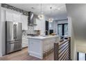 Open kitchen with stainless steel appliances, white cabinetry, island with seating and herringbone backsplash at 2323 Mason Dr # D21, Atlanta, GA 30316