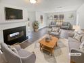 Bright living room with fireplace, large windows, modern furnishings, and wood-look flooring at 545 Zoie Ln, Palmetto, GA 30268