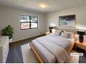 Staged bedroom features natural light from large window, stylish lamps and neutral decor for a calming retreat at 1750 Elizabeth Sw Ct, Conyers, GA 30094