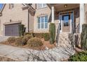 Inviting front entrance with brick facade, manicured shrubs, and walkway leading to the front door at 8955 Shalford Ct, Cumming, GA 30041