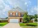 Charming two-story brick home featuring a two-car garage and a well-manicured front lawn at 3391 Meadow Grass Dr, Dacula, GA 30019