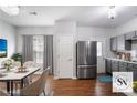 Modern kitchen and dining area featuring stainless steel appliances, gray cabinets, and hardwood floors at 1579 Eastern Sunrise Ln, Decatur, GA 30034