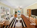 Bright, staged living room with hardwood floors, large windows and a ceiling fan at 7648 Mount Zion Blvd, Jonesboro, GA 30236