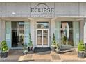 Welcoming entrance to Eclipse Buckhead building with manicured greenery, clean doors, and concrete facade at 250 Pharr Ne Rd # 1812, Atlanta, GA 30305