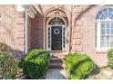 Close-up of a charming front door, brick entrance, and well-maintained landscaping at 7145 Hartsfield Pl, Suwanee, GA 30024