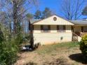 Side view of home with brick and siding exterior, showcasing the yard's potential and peaceful surroundings at 4574 Cedar Ridge Trl, Stone Mountain, GA 30083