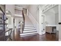 Grand foyer featuring a staircase, dark wood floors, and white trim at 789 Pathview Ct, Dacula, GA 30019