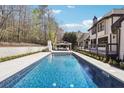 Backyard oasis with a sparkling pool, an outdoor kitchen, and a well-maintained deck with a view at 789 Pathview Ct, Dacula, GA 30019