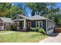 View of blue house with manicured front lawn with a short driveway on the right side at 1052 Donnelly Sw Ave, Atlanta, GA 30310