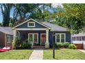 Charming blue home featuring a covered front porch and well-maintained landscaping at 1052 Donnelly Sw Ave, Atlanta, GA 30310