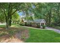Ranch home with a beautiful lawn, mature trees, and a side entry two-car garage at 3252 Westbrook Trce, Lawrenceville, GA 30044