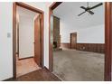 Open living room with brick fireplace, wood paneled walls, carpet floors, and a ceiling fan at 3252 Westbrook Trce, Lawrenceville, GA 30044