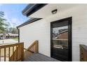 Exterior view of back deck with wooden railing and glass door in white siding of a home at 5780 Bearing Way, Atlanta, GA 30349