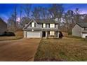 View of a two-story home with an attached garage, driveway, and well-maintained front lawn and fenced yard at 81 Summer Creek Dr, Dallas, GA 30157