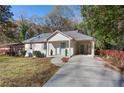 Well-lit, charming home with a covered carport and walkway leading to a light blue front door at 1649 Derry Sw Ave, Atlanta, GA 30310