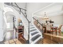 Bright foyer showcasing a staircase with wooden steps and white railings, complemented by hardwood floors and neutral decor at 2883 Misty Rock Cv, Dacula, GA 30019