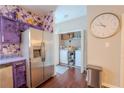 Modern kitchen with stainless steel fridge, custom purple cabinets, and adjacent laundry area, blending style and functionality at 7130 Oakley Ct, Union City, GA 30291